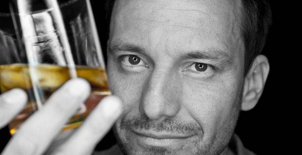 Man Studying Glass of Whisky Closeup